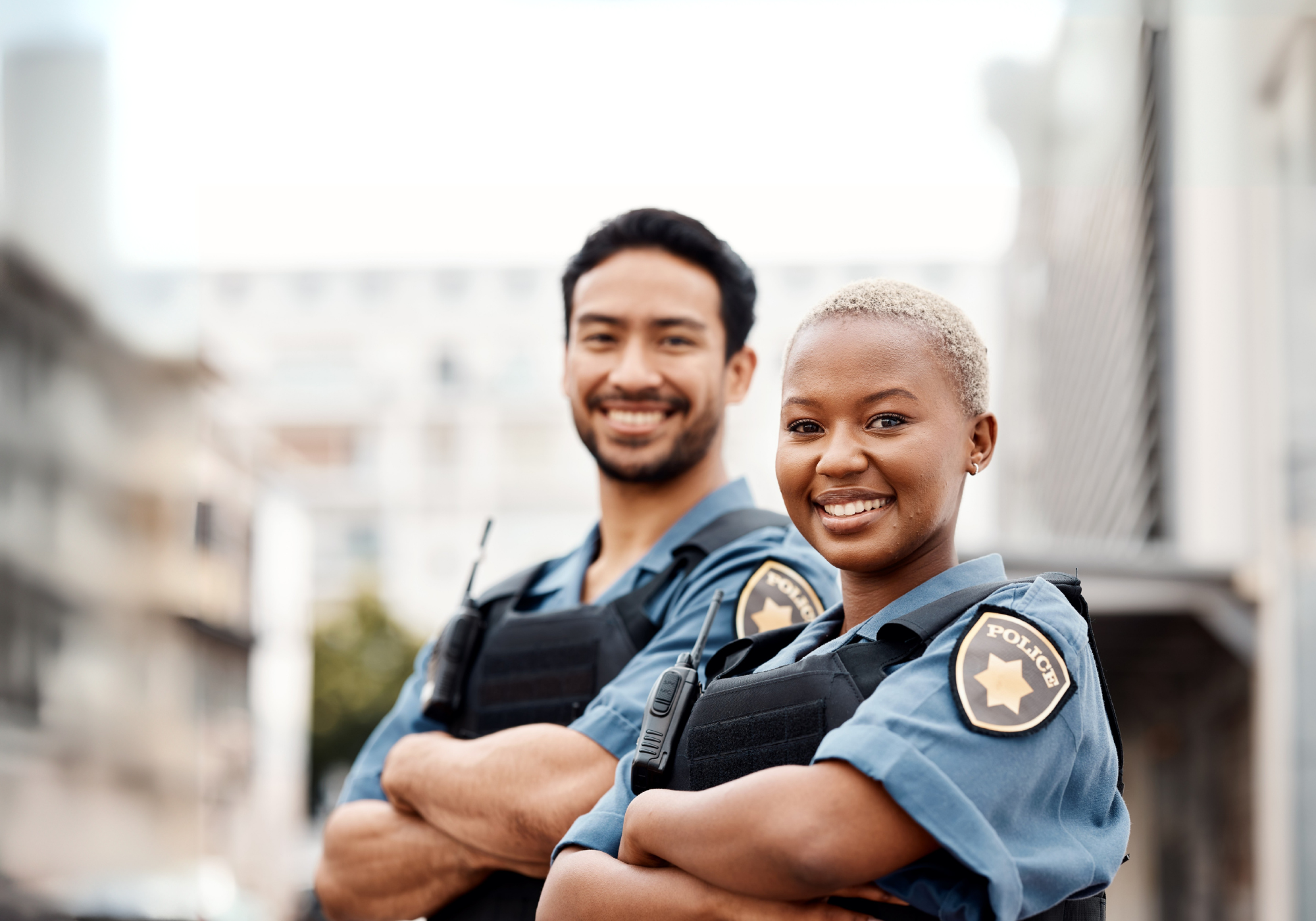 Two law enforcement officers smiling next to each other. 