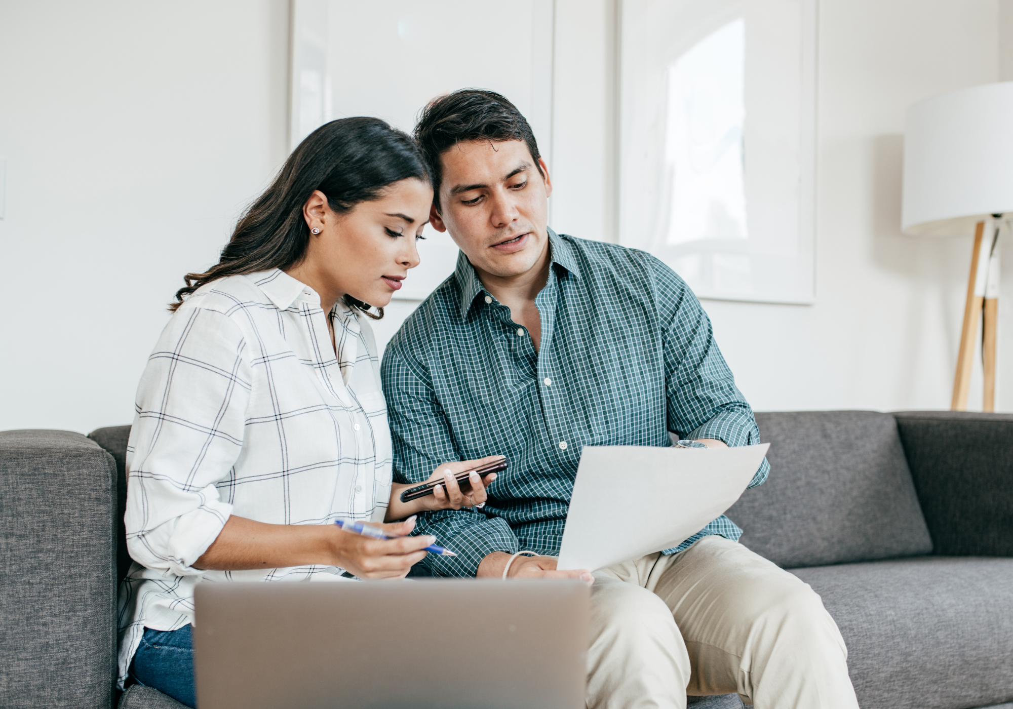 Couple reviewing household finances to improve their credit score before applying for a loan.